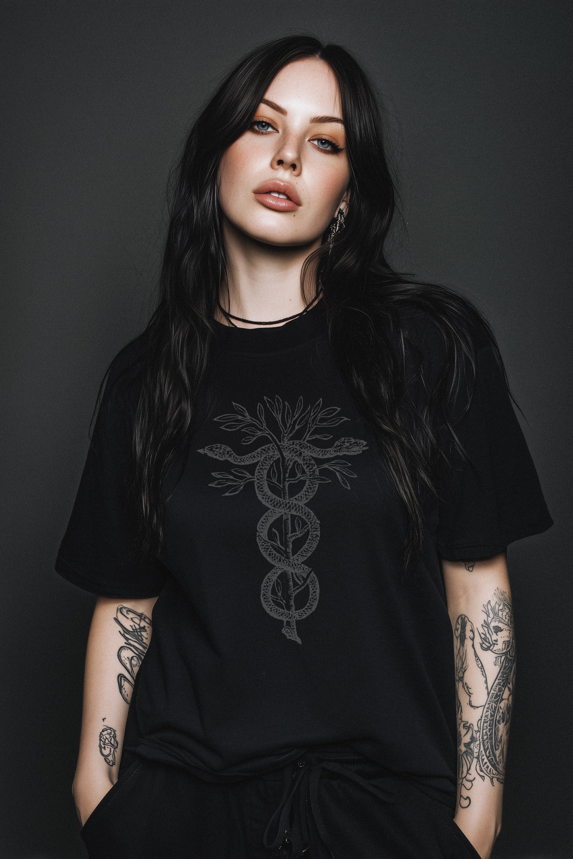Woman wearing a black t-shirt with a symbol design against a dark background