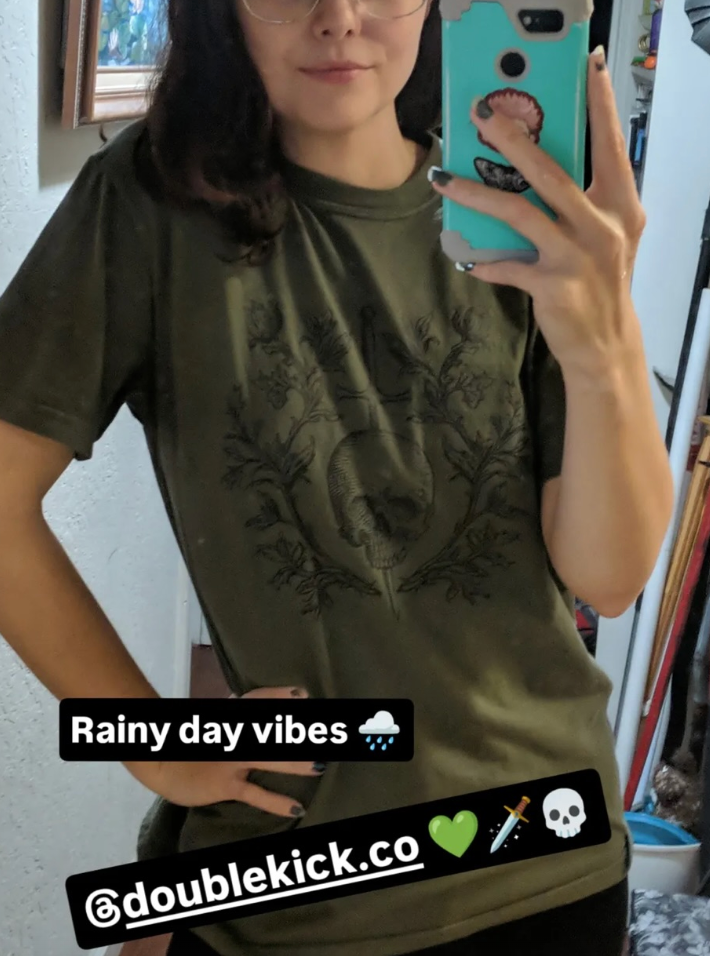 Person wearing a green t-shirt with text and branding