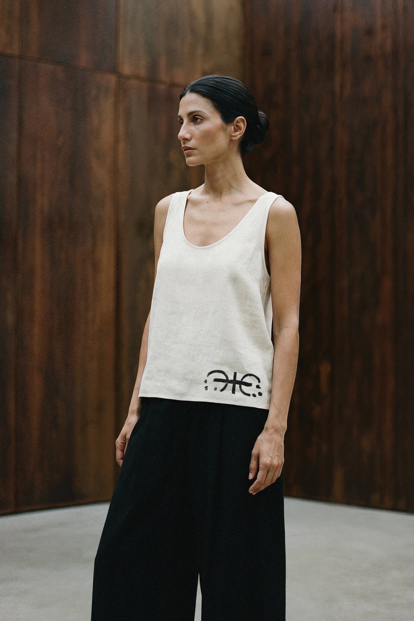 Woman standing in a hand painted custom linen tank top. Original artwork and clothing by Sara Kraus, Double Kick, alternative, small-batch, made-to-order, linen, artistic apparel and designs.