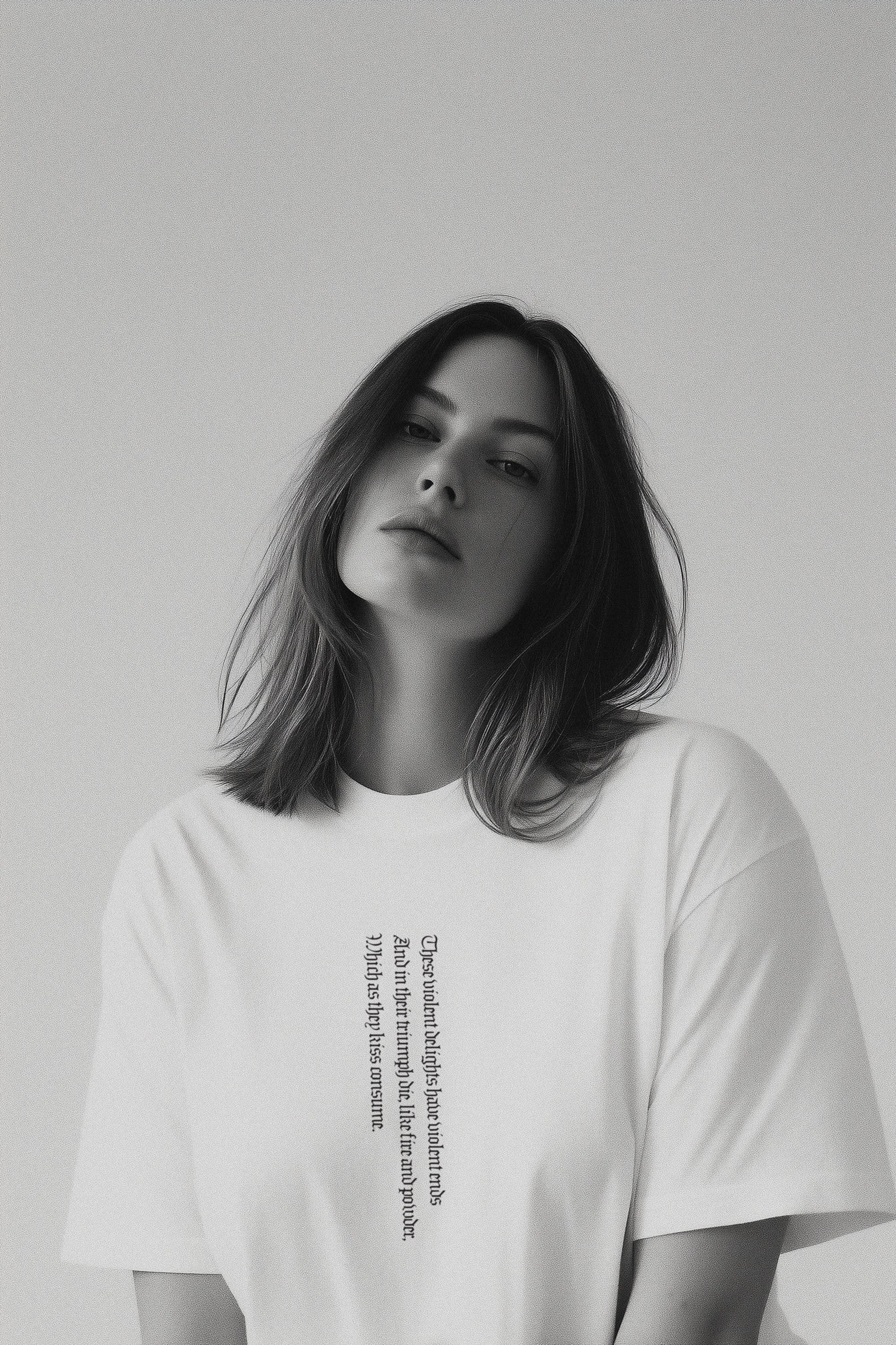 Person wearing a white t-shirt with text on a plain background